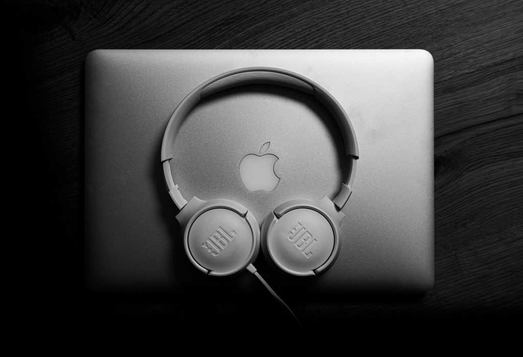 Black and white image of JBL headphones on a sleek laptop. Modern tech vibe.